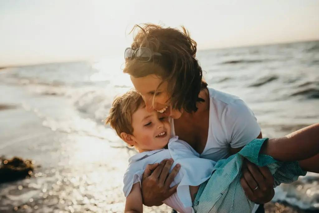 photo of mother and child beside body of water photo of mother and child beside body of water
