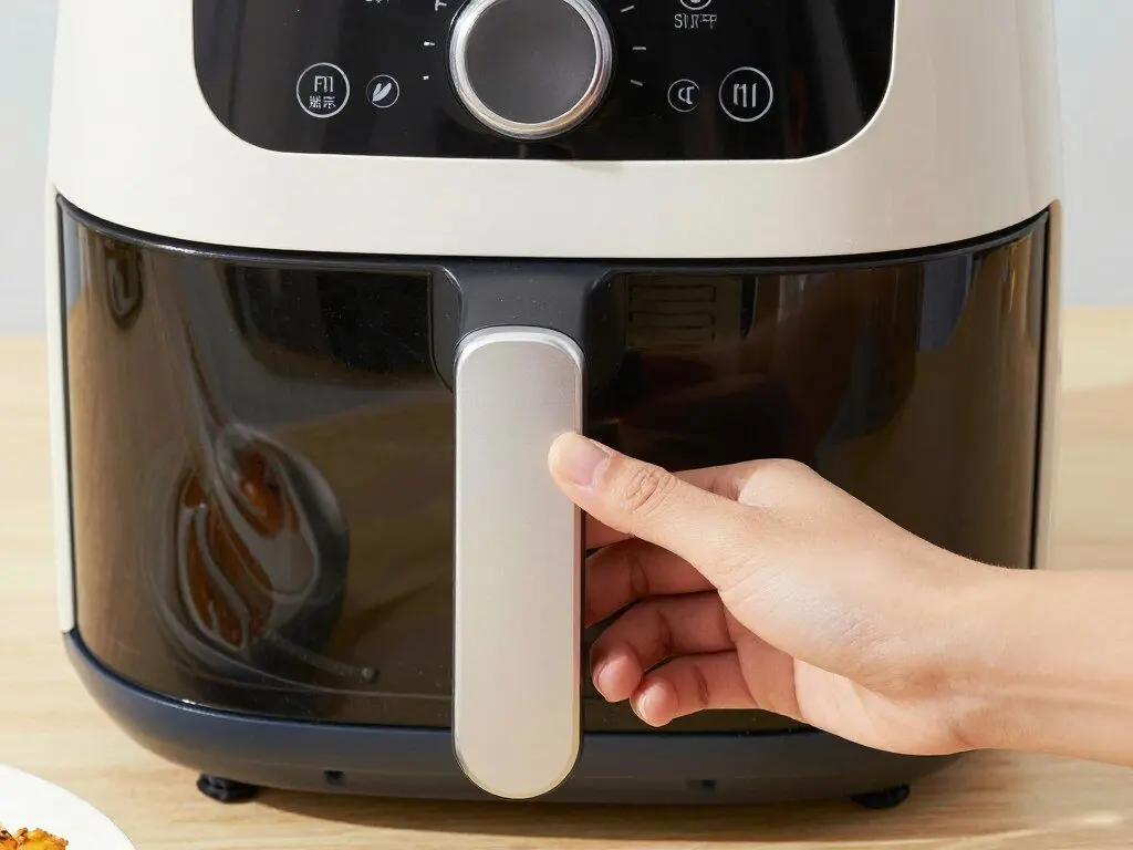 Air fryer with safety features highlighted including cool-touch exterior and auto shut-off