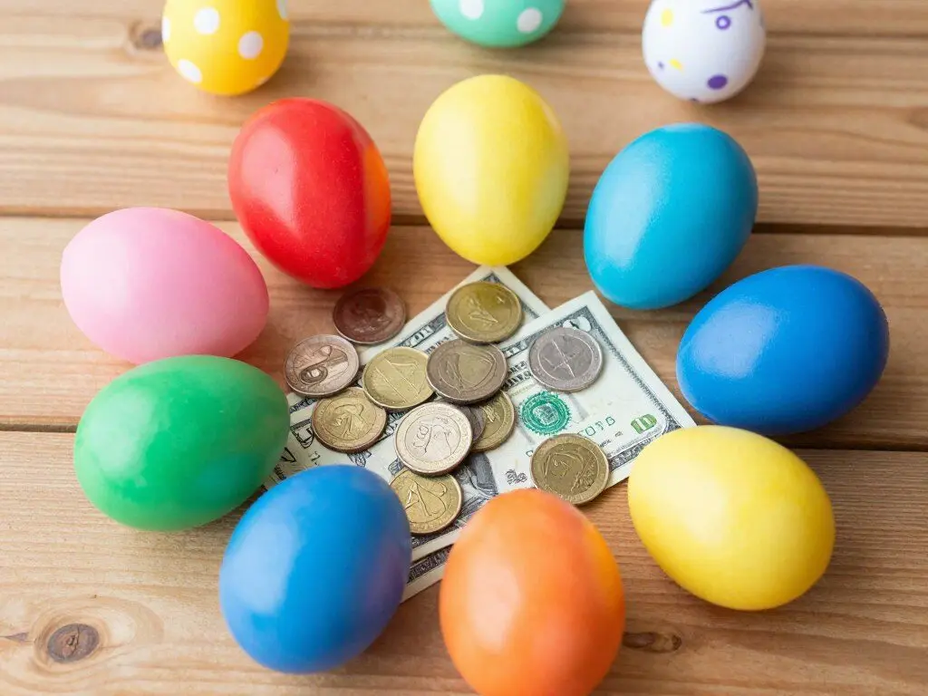 Plastic Easter eggs filled with coins and dollar bills scattered on table