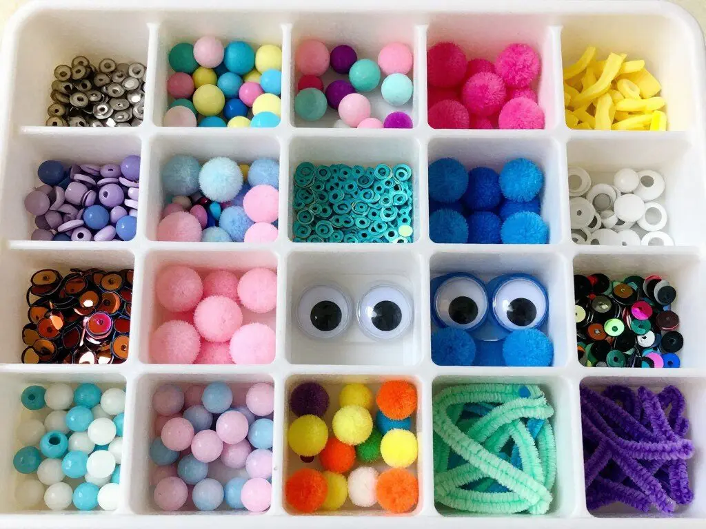 Small craft supplies including beads, pom poms, and googly eyes for Easter eggs