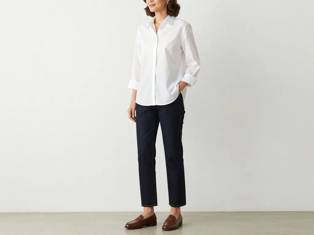 Woman over 50 in white button-down shirt and straight-leg jeans