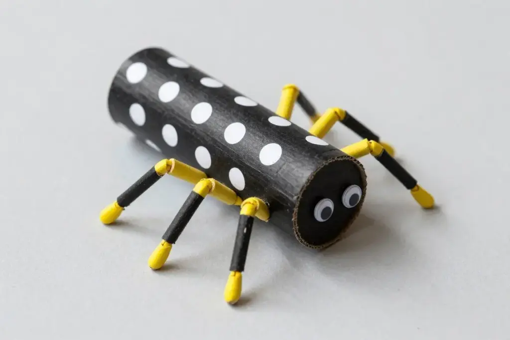 Black paper roll spider decorated with white and yellow polka dots Black paper roll spider decorated with white and yellow polka dots