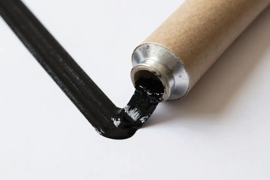 Child using a fringe-cut paper roll to stamp spider shapes in black paint Child using a fringe-cut paper roll to stamp spider shapes in black paint