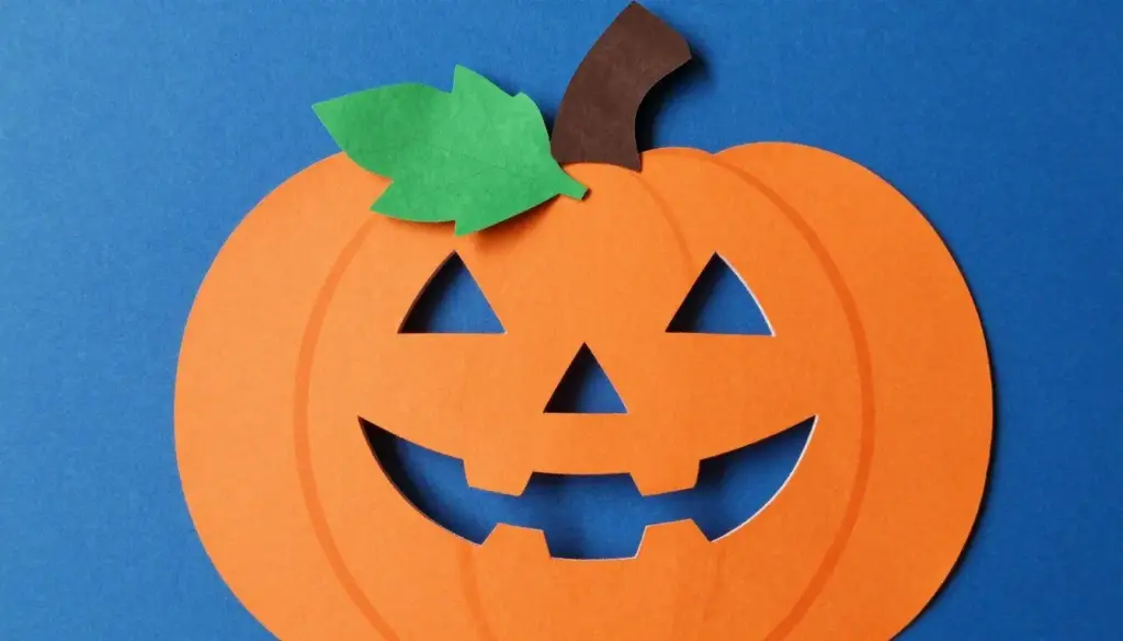 A flat paper pumpkin topped with a tightly rolled brown paper stem