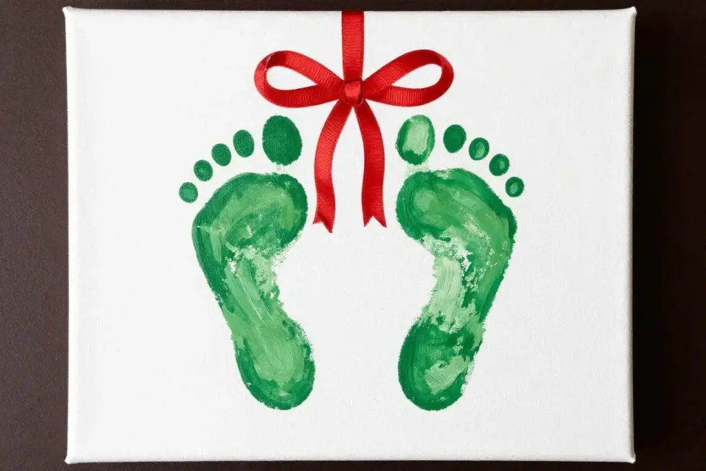 Green footprint mistletoe craft on canvas with red ribbon bow