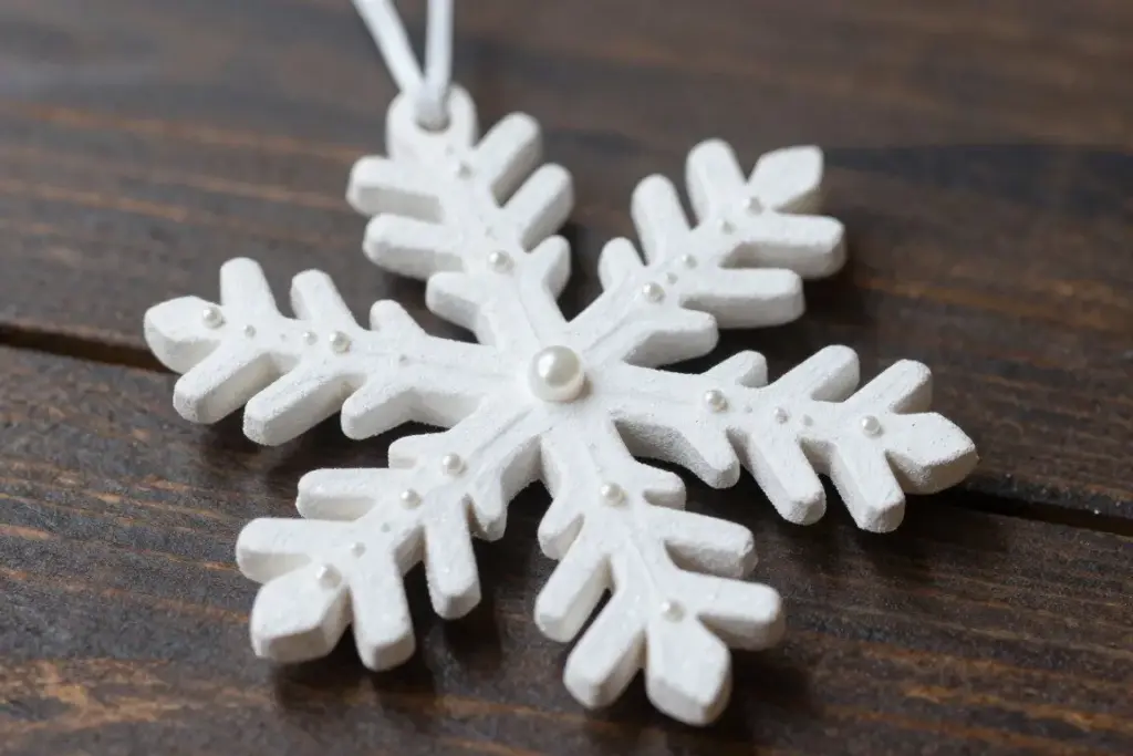 Intricate snowflake ornament constructed from dried pasta and painted white